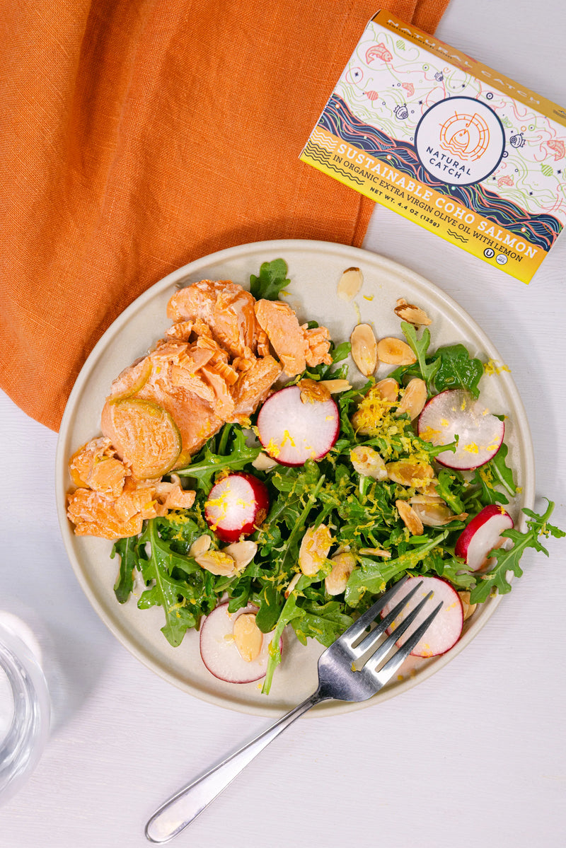Plated Coho salmon salad with fresh greens, sliced radishes, and toasted almonds