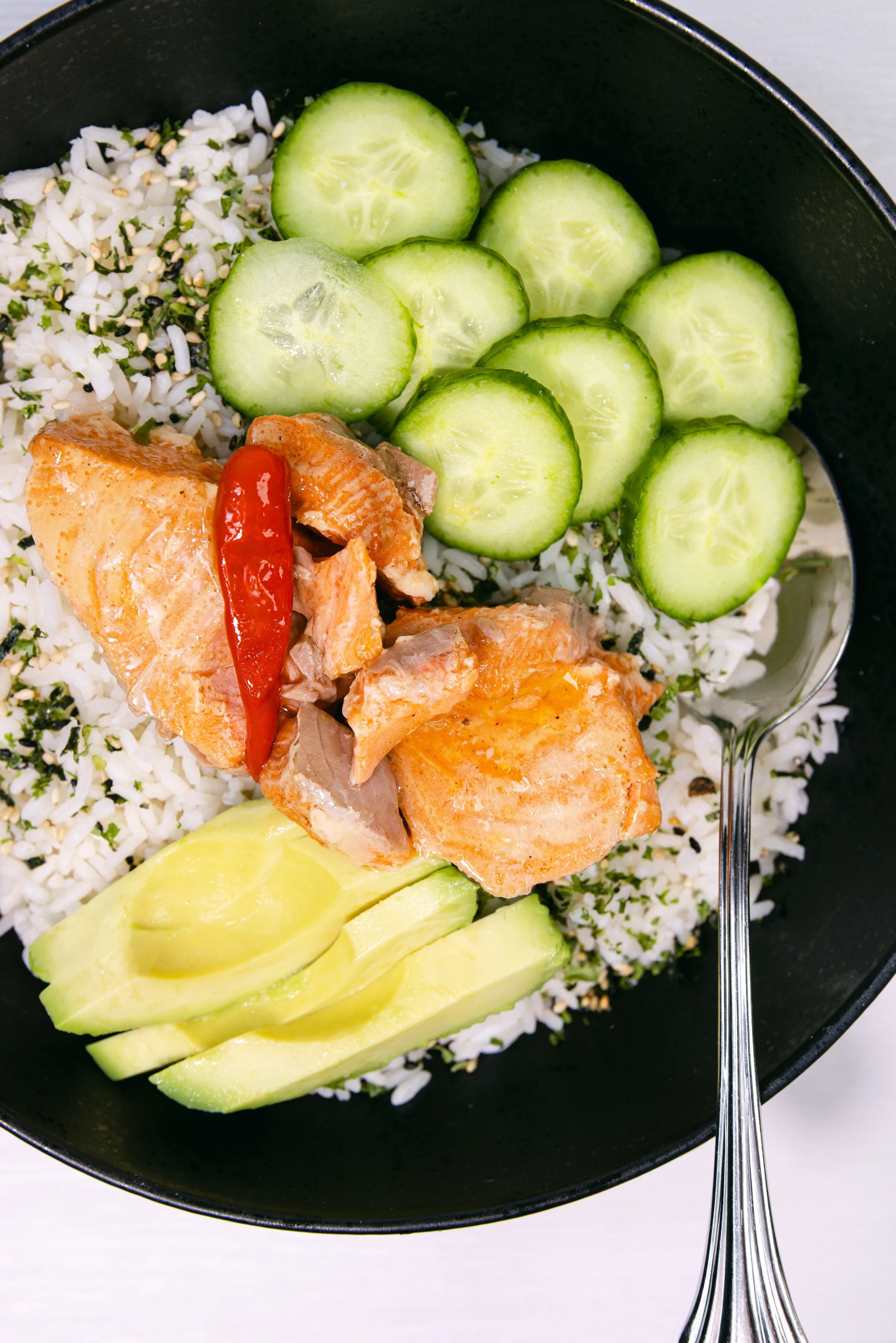 Natural Catch Coho salmon sushi bowl with steamed rice, sliced cucumbers, and fresh vegetables